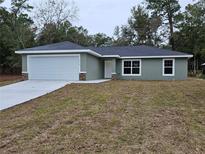 Newly built single-story home with attached garage and a flat yard at 9812 Sw 196Th Avenue Rd, Dunnellon, FL 34432