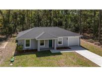 Charming single-story home with gray exterior, attached garage, and manicured front yard landscaping at 11404 Sw 131St Ter, Dunnellon, FL 34432