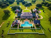 Expansive estate featuring a grand residence, pool with spas, guest houses, and lush green lawns at 17800 Se 237Th Ct, Umatilla, FL 32784