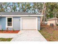 A one-car garage with a concrete driveway and recently landscaped garden at the front of the garage at 13374 Sw 112 St, Dunnellon, FL 34432