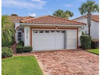 Charming home featuring a two-car garage, brick driveway, and a Spanish tile roof at 5162 Harbour Dr, Oxford, FL 34484