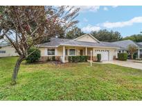 Charming home with a well-manicured front yard, a driveway and an attached garage at 9068 Sw 82Nd Ter # A, Ocala, FL 34481