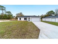 A charming single-story home features a two-car garage, well-maintained lawn, and a welcoming front facade at 13848 Sw 102 St, Dunnellon, FL 34432