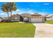 Charming single-story home featuring a well-maintained lawn, a two car garage, and a mature palm tree at 3864 Se 59Th Pl, Ocala, FL 34480