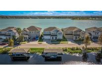 Aerial view of waterfront homes showcasing boat docks, lake views, and well manicured lawns on a sunny day at 455 Blue Cypress Dr, Groveland, FL 34736