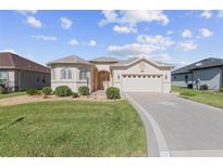 Charming single-story home featuring stucco exterior, manicured lawn, and a welcoming two-car garage at 10927 Se 168Th Loop, Summerfield, FL 34491