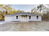 Charming single-story home with a well-maintained front yard and a classic white entryway at 21114 Sw Peach Blossom St, Dunnellon, FL 34431
