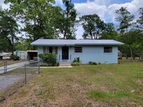 Charming single-story home with a metal roof and a well-maintained lawn with established landscaping at 2605 Ne 14Th Ave, Ocala, FL 34470