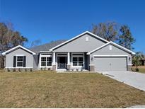 Gray two-story house with a two-car garage and landscaped lawn at 7587 Sw 103Rd Loop, Ocala, FL 34476