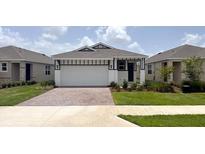Charming single-story home featuring a manicured lawn, brick driveway, and a welcoming two-car garage at 4082 Nw 44Th Cir, Ocala, FL 34482
