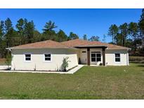 Inviting single-story home features a well-manicured lawn and a welcoming front porch, ideal for relaxation at 12205 Sw 71St Lane Rd, Ocala, FL 34481