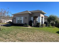 Tan house with white columns, landscaping, and a black fence at 3642 Nw 55Th Cir, Ocala, FL 34482