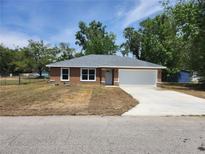Charming one-story home featuring a two-car garage and manicured lawn on a sunny day at 3733 Se 137Th Street, Summerfield, FL 34491