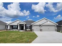 Beautiful single Gathering home featuring a 3-car garage and well-maintained lawn with decorative stone accents at 8309 Sw 58Th Ave, Ocala, FL 34476