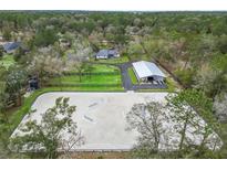 Expansive aerial view of horse training facility with riding arena, stables, pastures, and charming residence at 965 Nw 73Rd Ter, Ocala, FL 34482