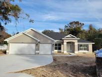 Newly constructed home with two-car garage and neutral exterior at 7703 Sw 103Rd Loop, Ocala, FL 34476