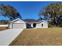 Charming single-story home with a well-manicured lawn and a freshly painted gray exterior at 7605 Sw 103Rd Loop, Ocala, FL 34476