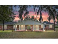 Brick ranch house with covered porch, under a sunset sky at 8544 Nw 160Th Ave, Morriston, FL 32668