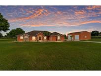 Charming single-story home featuring a lush lawn, stone accents, and a matching garage at 9901 Nw 6Th Ct, Ocala, FL 34475