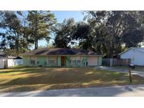 Light green house with a yard, and trees around it at 35 Hemlock Terrace Dr, Ocala, FL 34472