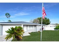 Newly renovated home with gray exterior, landscaping, and American flag at 7 Teak Loop Pl, Ocala, FL 34472