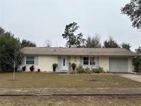 Ranch style home with a well-maintained lawn and attached garage at 14788 Sw 39Th Cir, Ocala, FL 34473