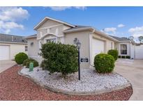 Charming single-story home with attached garage, manicured landscaping, and well-lit entrance at 1673 Belle Grove Dr, The Villages, FL 32162