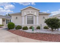 Charming single-story home with manicured landscaping, decorative stone, and architectural details at 1673 Belle Grove Dr, The Villages, FL 32162