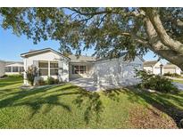 Charming home featuring a well-manicured lawn and an inviting patio area, perfect for outdoor living at 2427 Due West Dr, The Villages, FL 32162