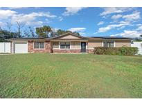 Charming single-story home with a well-maintained lawn and a mix of stone and stucco exterior finishes at 6931 Se 54Th St, Ocala, FL 34472