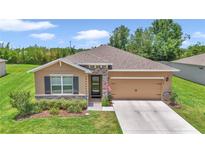Beautiful single-story home featuring stone accents, manicured landscaping, and a two-car garage at 6365 Sw 88Th Loop, Ocala, FL 34476