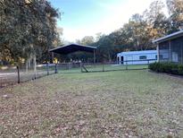 Large backyard with covered shelter, storage shed, and fenced area at 11064 Ne 212Th Ln, Fort Mc Coy, FL 32134
