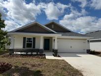 Charming single-story home with a two-car garage, landscaped yard, and stone accents on the facade at 2134 Nw 23Rd Loop, Ocala, FL 34475