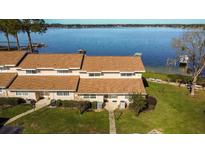 Waterfront condo complex featuring well-maintained landscaping and private docks on a sunny day at 11001 Se Sunset Harbor Rd # B10, Summerfield, FL 34491