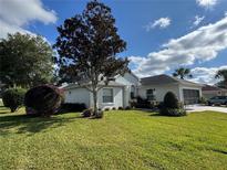 Charming single-story home with manicured lawn and mature landscaping, creating inviting curb appeal at 11147 Sw 68Th Ct, Ocala, FL 34476