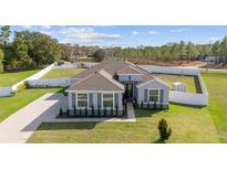 Inviting single-story home featuring manicured landscaping, modern colors, and a well-maintained lawn at 4812 Se 37Th St, Ocala, FL 34480