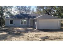 Newly constructed home with gray exterior, attached garage, and landscaping at 24268 Sw Tiger Lake W Blvd, Dunnellon, FL 34431