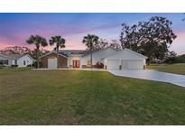 Two-story home with a three-car garage and manicured lawn at 17999 Se 99Th Ave, Summerfield, FL 34491
