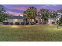 Beautiful sunset view of the exterior featuring mature palms and a manicured front lawn at 2105 Sw 4Th St, Ocala, FL 34471