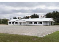White horse barn with cupola and black window accents at 2190 Nw 110Th Ave, Ocala, FL 34482