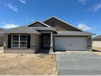 Charming single-story home with a gray roof, a two-car garage, and stucco siding, set against a bright blue sky at 3154 Ne 46Th Ave, Ocala, FL 34470