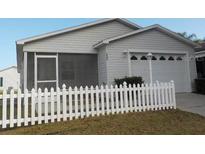 Cute house with white picket fence and a two-car garage at 321 Katherine Pl, The Villages, FL 32162