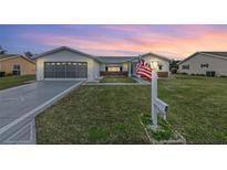 House exterior featuring a two-car garage and landscaped lawn at 9802 Se 178Th Ln, Summerfield, FL 34491