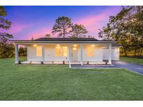 White house with front porch, driveway, and landscaped lawn at 15002 Sw 27 St, Ocala, FL 34481