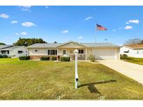 Single-story home with attached garage and well-manicured lawn at 17890 Se 96Th Ct, Summerfield, FL 34491