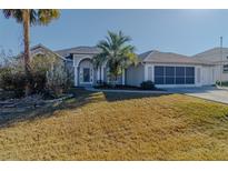 One-story home with gray exterior, palm trees, and a screened porch at 2045 Nw 56Th Ter, Ocala, FL 34482