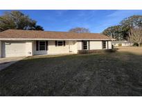 Ranch-style home with brown roof and mature landscaping at 2191 Ne 40Th St, Ocala, FL 34482