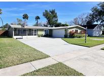 Green house with large driveway, landscaping, and basketball hoop at 2241 Brian Ave, South Daytona, FL 32119