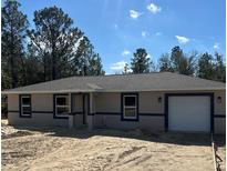 New single-story home featuring a neutral color palette and attached two-car garage at 22564 Sw Rainbow Lakes Blvd, Dunnellon, FL 34431