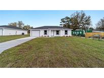 Charming single-story home featuring a well-maintained front yard, attached garage and neutral color palette at 2397 Sw 143 Ct, Ocala, FL 34481